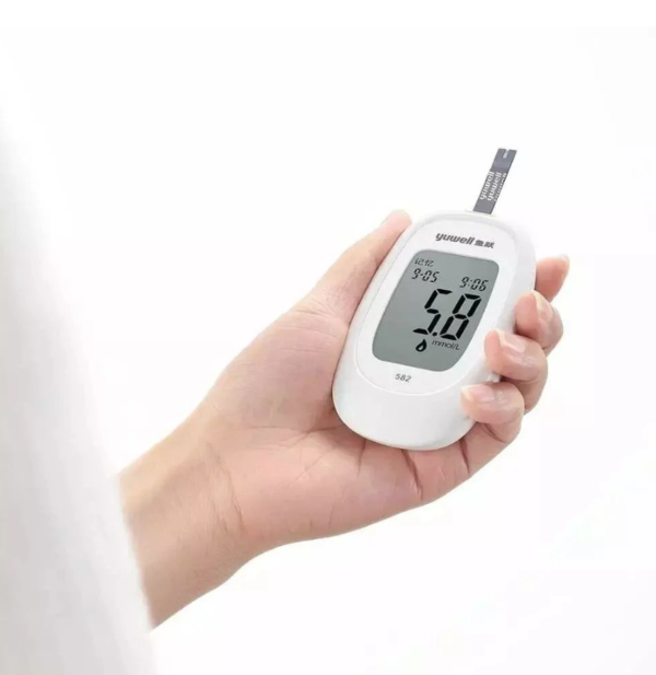 Hand holding portable digital glucose meter for diabetes check