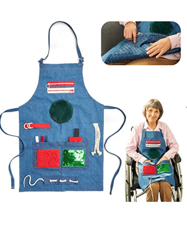 Elderly woman in wheelchair wearing sensory stimulation apron.