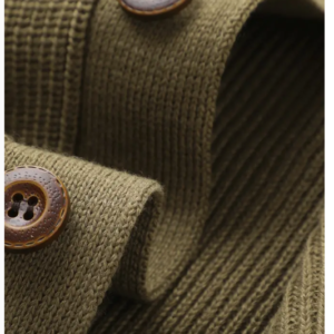 Close-up of brown buttons on olive green cardigan