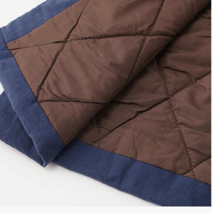 Close-up of a quilted brown and blue blanket.