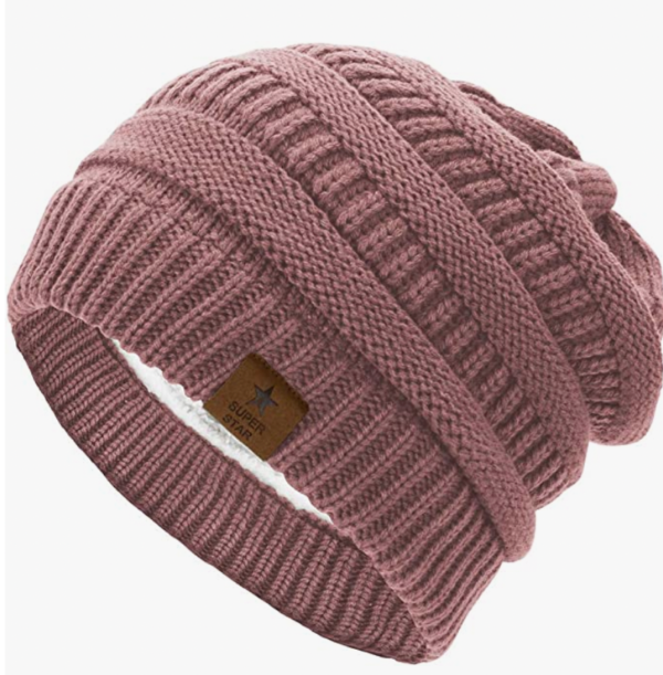 Warm pink knitted beanie hat on white background.